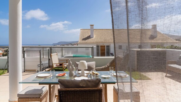 Un coin repas avec une table dressée pour deux personnes, offrant une vue panoramique.
