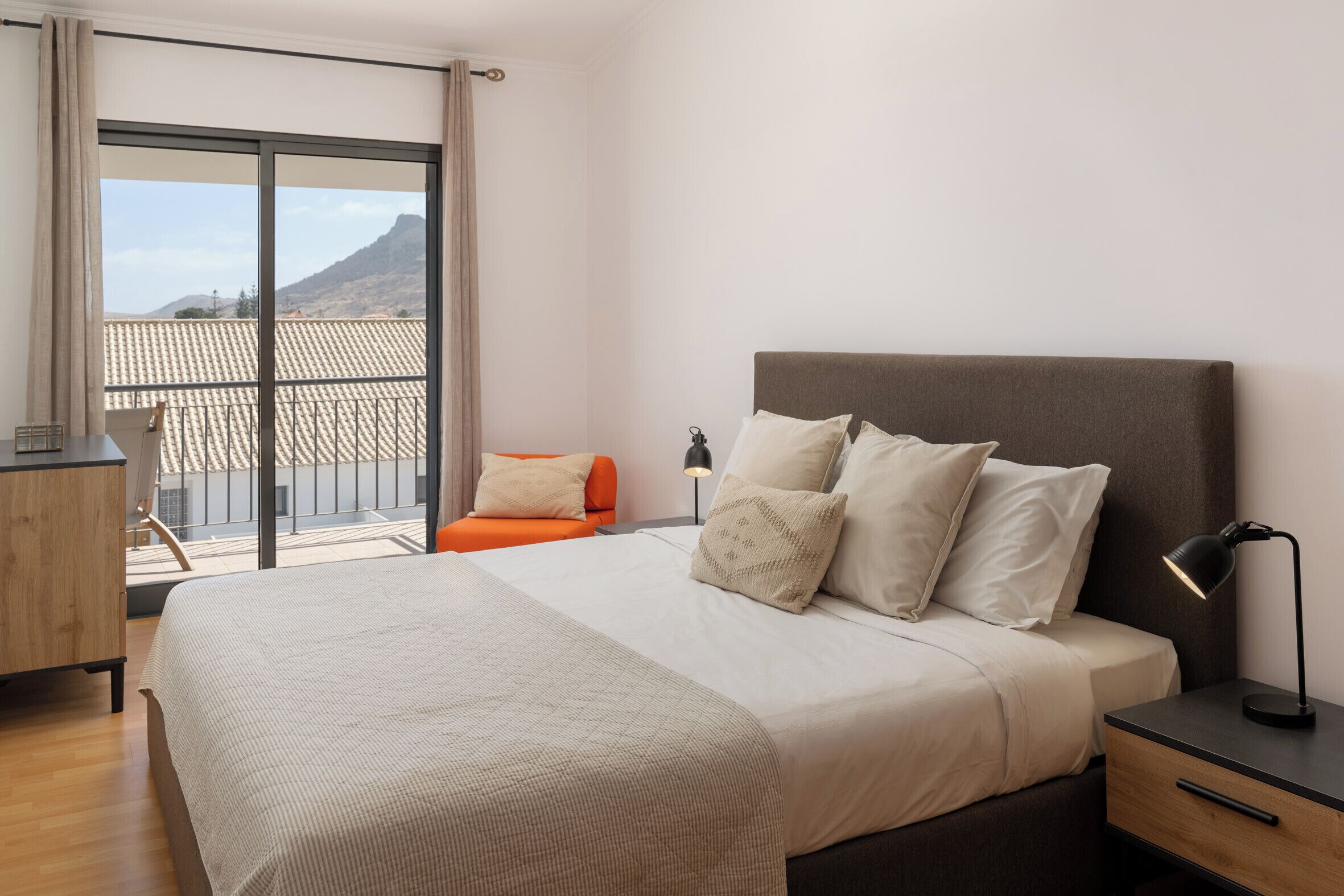 Una camera da letto con un letto grande, un comodino, una scrivania e una sedia.