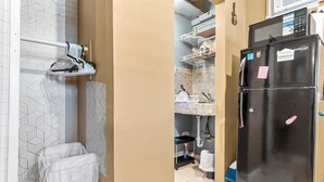 A kitchen with a black refrigerator, a microwave, and a sink. There is a broom and a mop on the floor. - Modern comfortable close to the beach/airport (Fort Lauderdale)