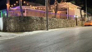 Un bâtiment avec un mur en pierre et des guirlandes lumineuses.