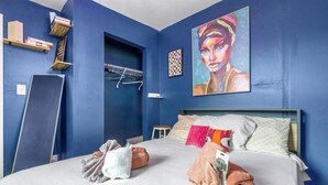 Ein Hotelzimmer mit einem großen Bett, einem Bild an der Wand und einer blauen Wand.