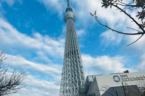 A tall tower with a spire, surrounded by a clear sky with some clouds. - YOSHIFUSA TOKYO (Tokyo)