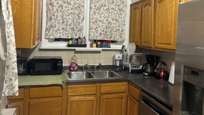 A kitchen with wooden cabinets, a microwave, a coffee maker, and a dishwasher.