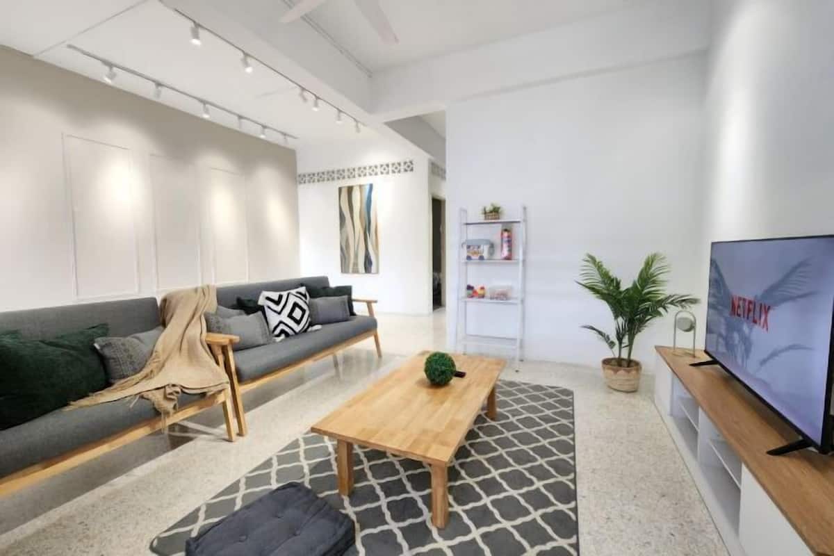 En moderne stue med sofa, sofabord og fjernsyn.