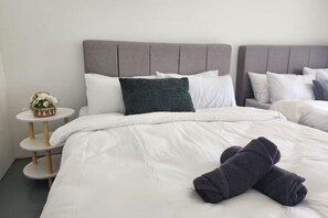 A hotel room with a bed, pillows, a bedside table with a lamp, and a small decorative item. - Petaling Jaya 5 BedRoom Landed SS17/ for up to 18pax/Jaya1/Phileo/UM (Petaling Jaya)