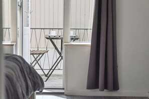 A room with a view of a balcony, a small table, and a chair. - Cosy and modern house in peaceful setting (Otterup)