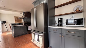 A modern kitchen with grey cabinets, a stainless steel refrigerator, a microwave, and a coffee maker. - Amazing Condo In Downtown Alhambra, 20 minutes to DTLA, 10 minutes to Pasadena (Alhambra)