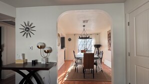 A dining area with a table and chairs, a chandelier, and a view through an archway to another room. - Amazing Condo In Downtown Alhambra, 20 minutes to DTLA, 10 minutes to Pasadena (Alhambra)