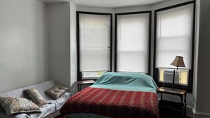 A bedroom with a bed, a sofa, and a lamp. - 1 bedroom apartment across from Temple Hospital (Philadelphia)