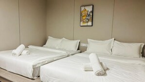A hotel room with two beds, each with white linens and towels, a neutral color wall, and a single artwork above the beds. - All-You-Need Room for 4 Walk & Drive Around to Tourist Hotspot Eden (Melaka)