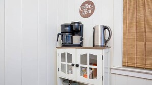 A kitchenette with a coffee maker, a kettle, and a coffee bar sign. - Charming Retreat Near WFU, Hospitals, & Top Spots (Winston-Salem)