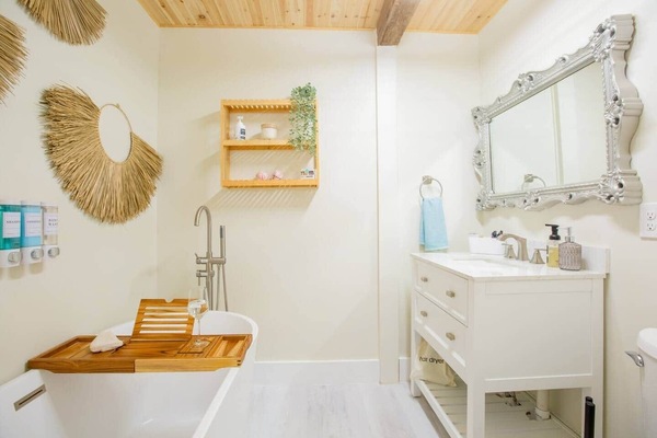 Spa-inspired bathroom with soaking tub, bath salts modern vanity & serene design