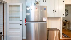 Ein Edelstahl-Kühlschrank mit Wi-Fi-Symbol, einem Rauchverbot-Schild und einem kleinen blauen Aufkleber.