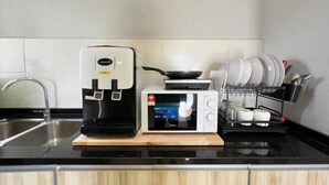A kitchen with a coffee maker, microwave, and dish rack. - RiverView 8Pax 3Br in KBtown PS4, Netflix A-1-2 (Kota Bharu)