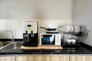 A kitchen with a coffee maker, microwave, and a dish rack. - RiverView 8Pax 3Br in KBtown PS4, Netflix A-1-2 (Kota Bharu)