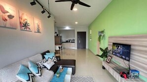 A modern living room with a sofa, coffee table, TV, and artwork on the wall. - RiverView 8Pax 3Br in KBtown PS4, Netflix A-1-2 (Kota Bharu)
