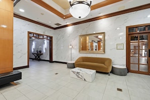 A lobby with a marble floor, a sofa, a coffee table, a floor lamp, and a mirror on the wall. - Near NYC • Inviting Double Suite • Sleeps 4 • Prime Location (Carteret)