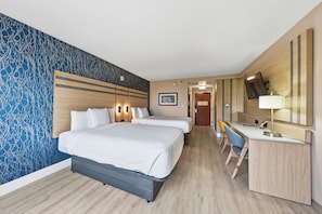 A hotel room with a large bed, a desk, and a chair. There is a mirror and a picture on the wall. - Near NYC • Inviting Double Suite • Sleeps 4 • Prime Location (Carteret)