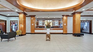 A hotel lobby with a reception desk, seating area, and a large circular ceiling light. - Near NYC • Inviting Double Suite • Sleeps 4 • Prime Location (Carteret)