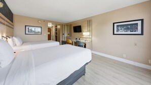 A hotel room with a large bed, a desk, a chair, a television, and two framed pictures on the wall. - Near NYC • Inviting Double Suite • Sleeps 4 • Prime Location (Carteret)
