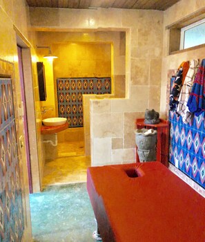 A bathroom with a sink, a mirror, a red bathtub, and a patterned wall. - The Dock Resort  (Roatan)
