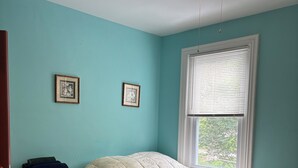 Un dormitorio con cama, armario y ventilador de techo.