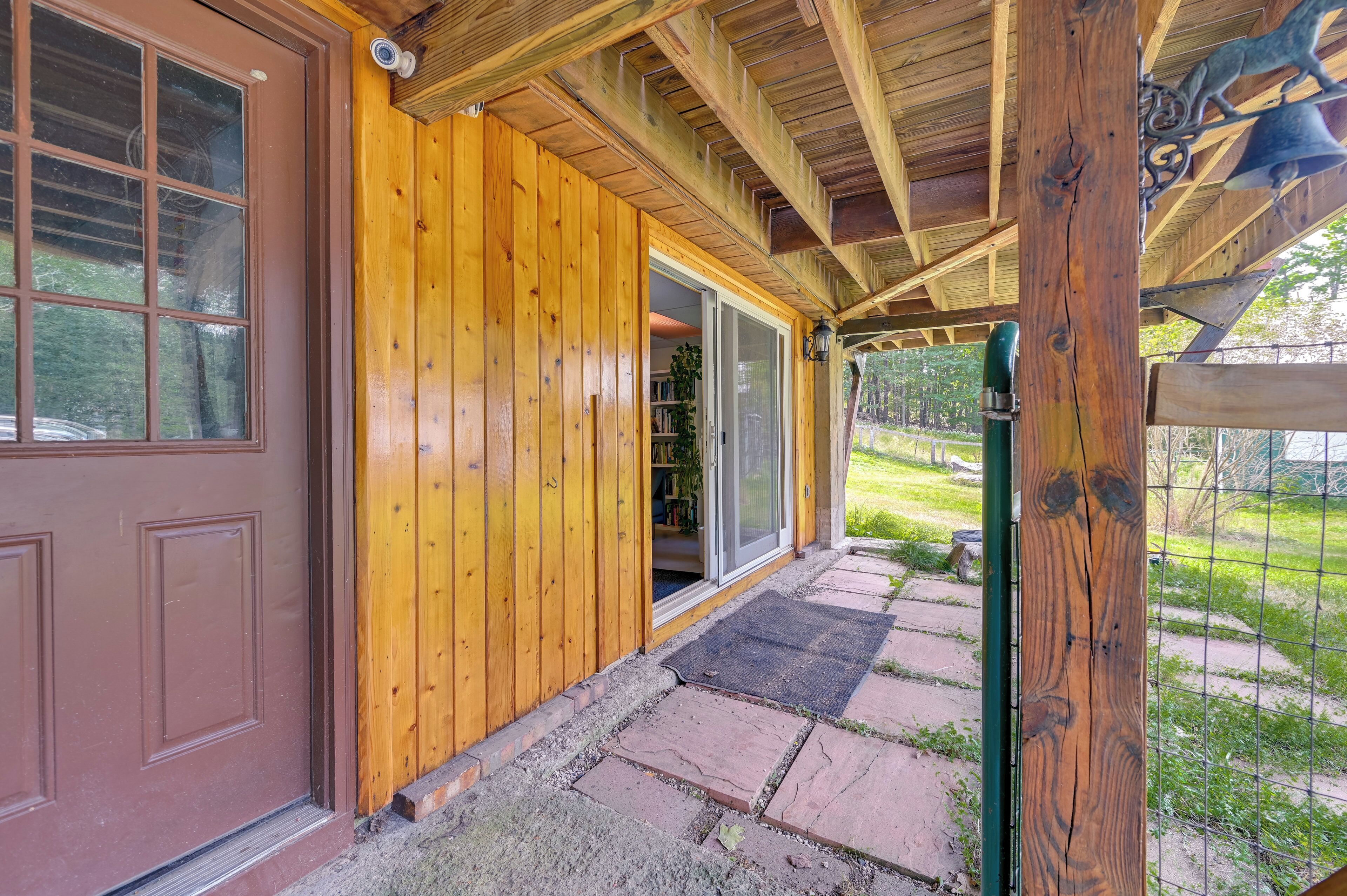 A wooden exterior with a brown door and a glass door leading to a covered porch.