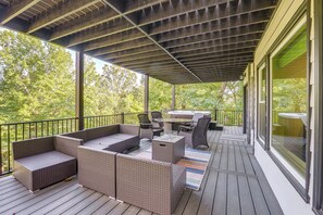 Une terrasse extérieure avec des meubles en osier, une table et des chaises.
