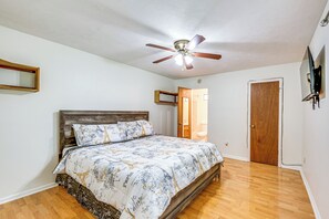 A bedroom with a wooden bed, a ceiling fan, and a wooden door. - Quiet & Convenient Tallahassee Home, 4 Mi to Lake! (Tallahassee)