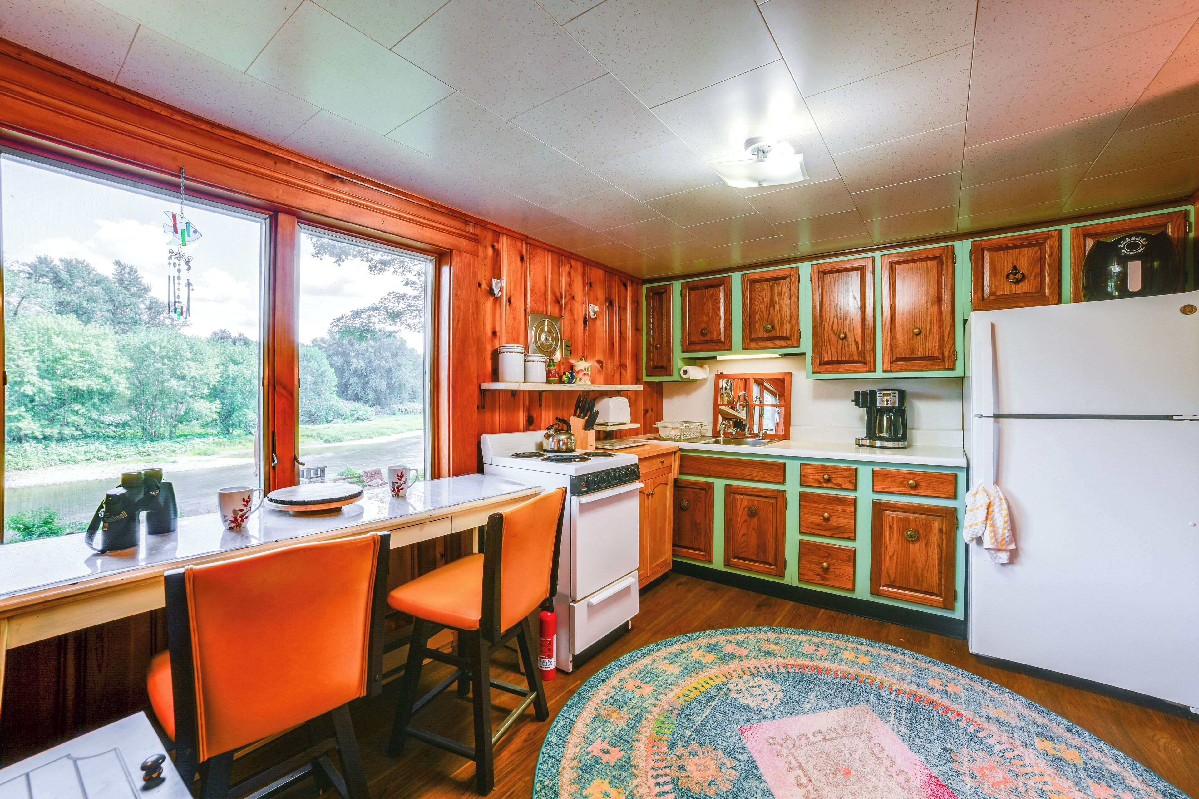 A kitchen with wooden cabinets, a stove, and a refrigerator.