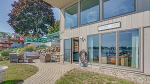 Ein Gebäude mit einem Schild, auf dem 'Welcome to the Porch' steht, Außenbestuhlung und Blick aufs Wasser.
