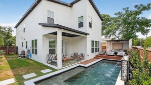 A two-story house with a swimming pool, outdoor seating, and a fenced yard. - The Hugo | Sleeps 10 (Dallas)