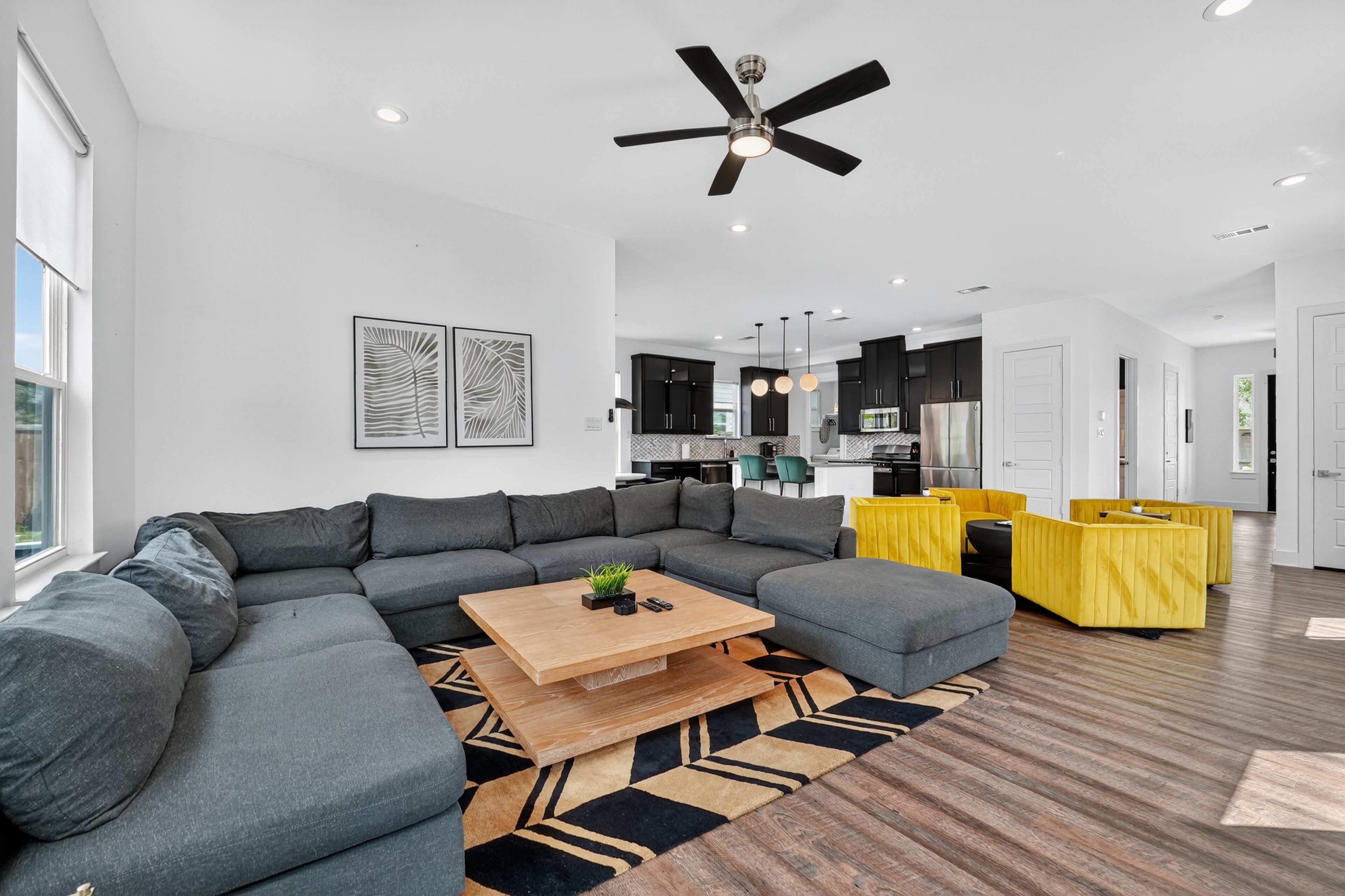 A modern living room with a sectional sofa, a wooden coffee table, and a patterned rug.