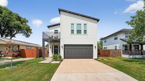 A modern two-story house with a garage, a covered patio, and a well-maintained lawn. - The Hugo | Sleeps 10 (Dallas)