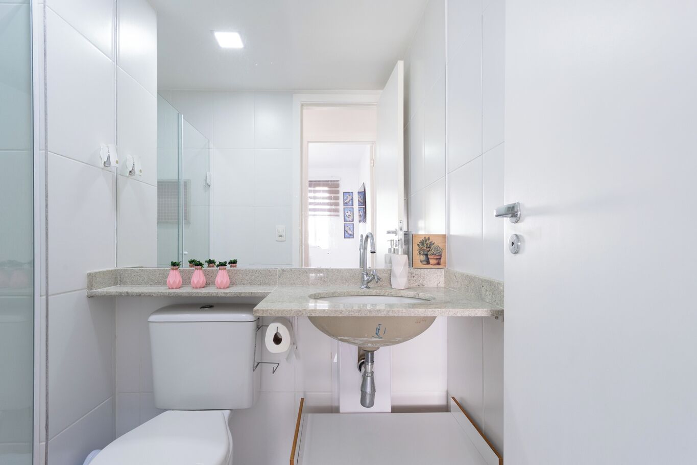 A modern bathroom with a white toilet, a sink with a vanity, and a shower area.