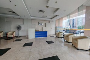 A hotel lobby with a reception desk, seating area, and large windows. - Meetsuite at Kota Kinabalu (Kota Kinabalu)
