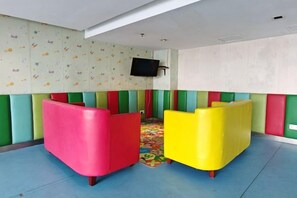 A children's play area with colorful padded seating and a patterned wall. - Meetsuite at Kota Kinabalu (Kota Kinabalu)