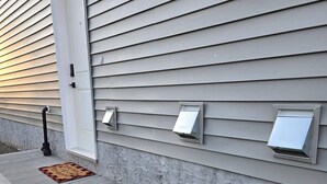 A house with gray siding, a concrete porch, and three metal outdoor light fixtures mounted on the wall. - Welcoming and Spacious 1-bedroom unit in Edmonton (Edmonton)