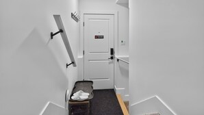 A narrow hallway with a white door, a coat rack, and a shoe rack. - Welcoming and Spacious 1-bedroom unit in Edmonton (Edmonton)