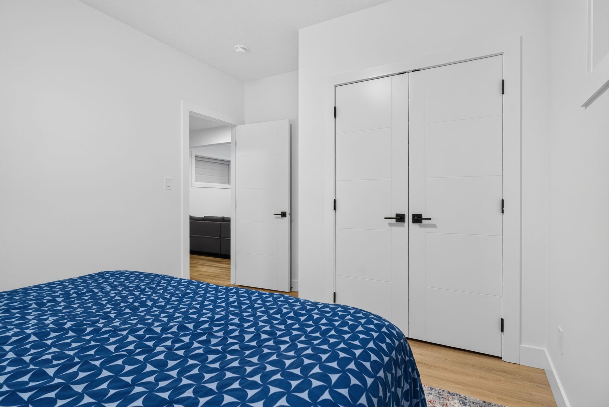 A bedroom with a bed, a wardrobe, and a door leading to a bathroom.