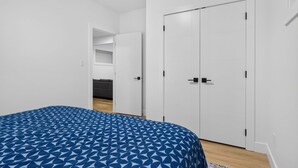 A bedroom with a bed, a wardrobe, and a door leading to a bathroom. - Welcoming and Spacious 1-bedroom unit in Edmonton (Edmonton)