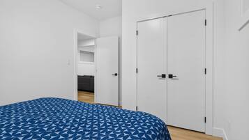 A bedroom with a bed, a wardrobe, and a door leading to a bathroom.