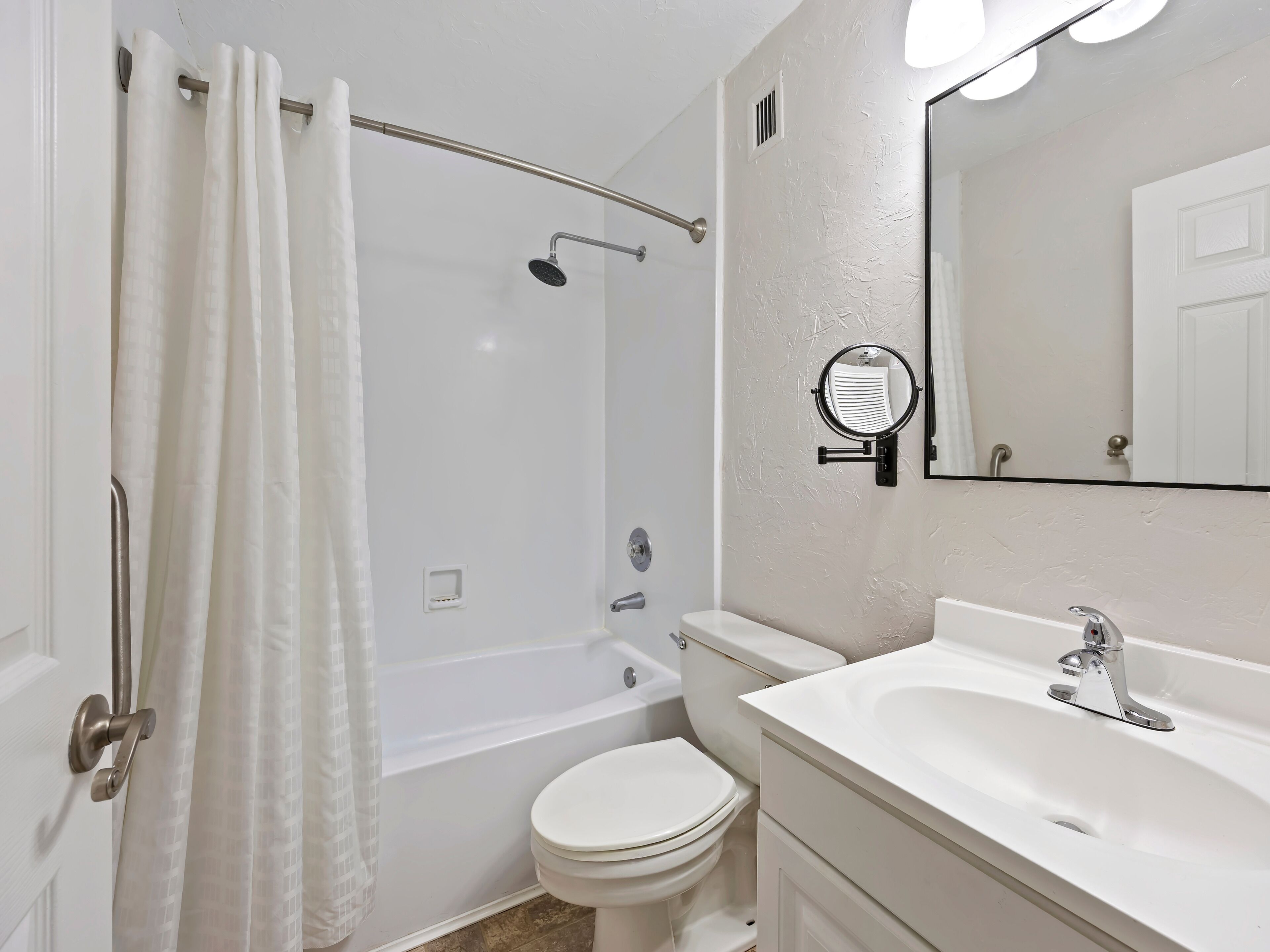 A bathroom with a bathtub, toilet, and sink.