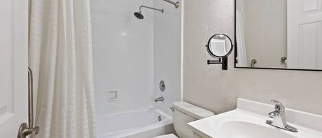 A bathroom with a bathtub, toilet, and sink.