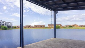 A wooden deck overlooking a calm lake with a clear sky. - The Howdy Hangout near Texas A&M and Kyle Field (College Station)
