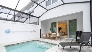 Un espace piscine doté d’un jacuzzi, de coins salon extérieurs et d’une terrasse couverte.