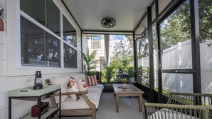 A sunlit covered patio with a sofa, a table, and a chair. - Chic 3BR villa Game Room close to Disney + Resort (Davenport)