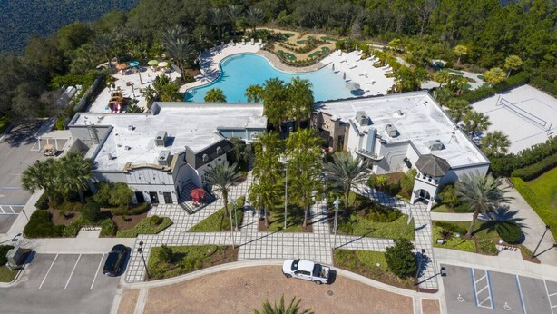 An aerial view of a resort with a swimming pool, a golf course, and a parking area. - Chic 3BR villa Game Room close to Disney + Resort (Davenport)