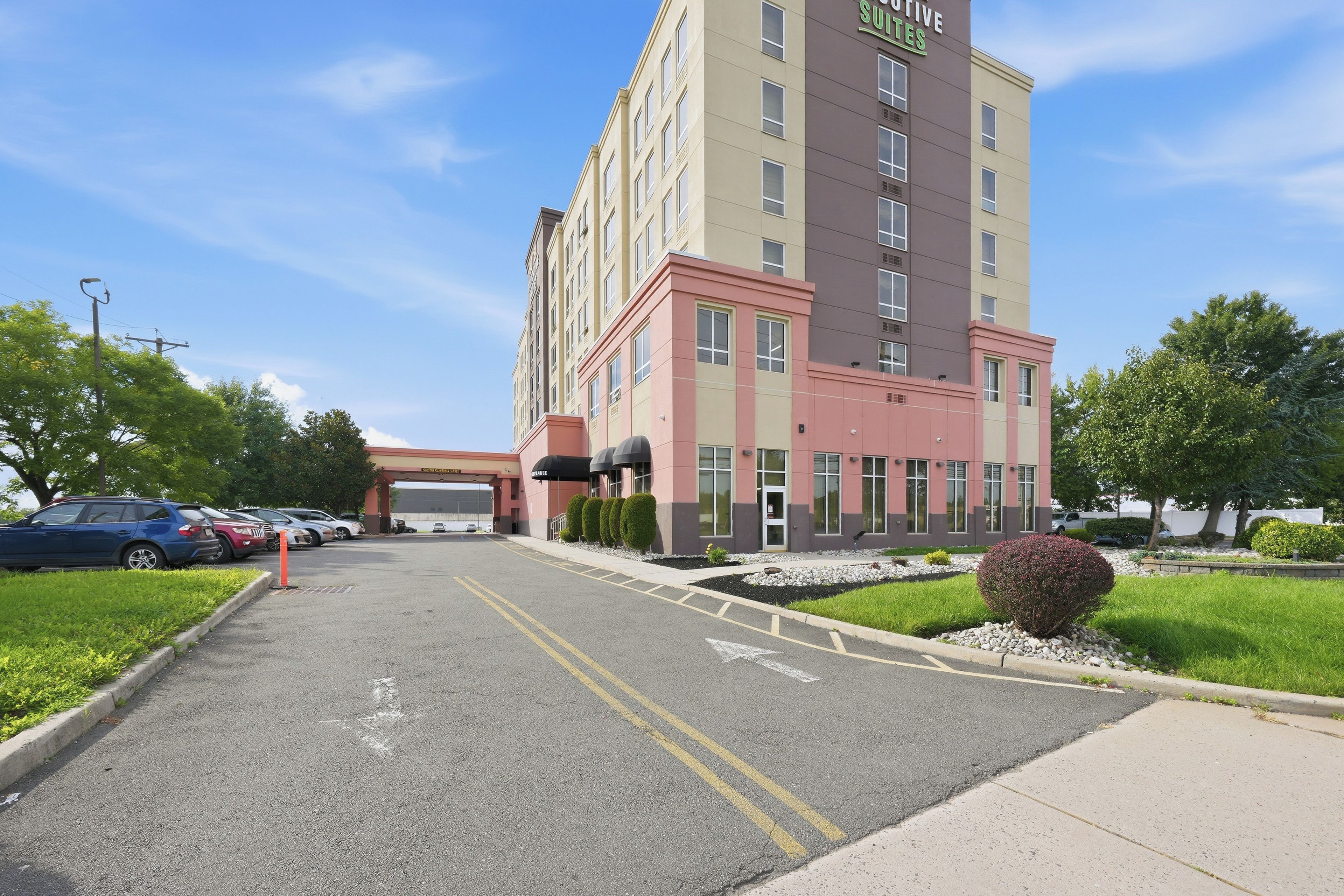 A multi-story hotel with a parking lot in front.