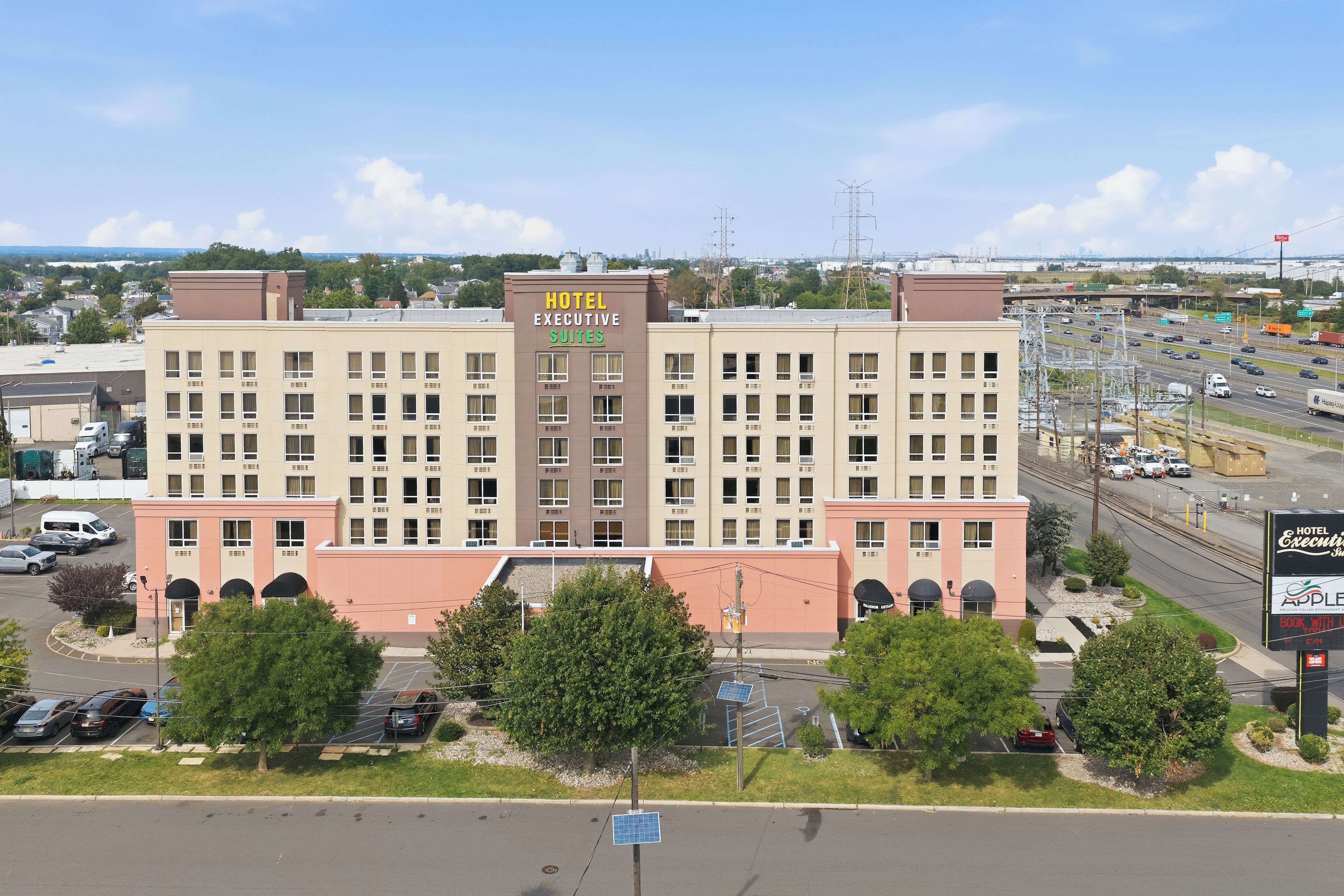 A multi-story hotel with a sign indicating 'Hotel Executive Suites.'